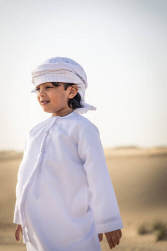 Happy family playing in the desert of Dubai -  Playful father and his son having fun outdoors